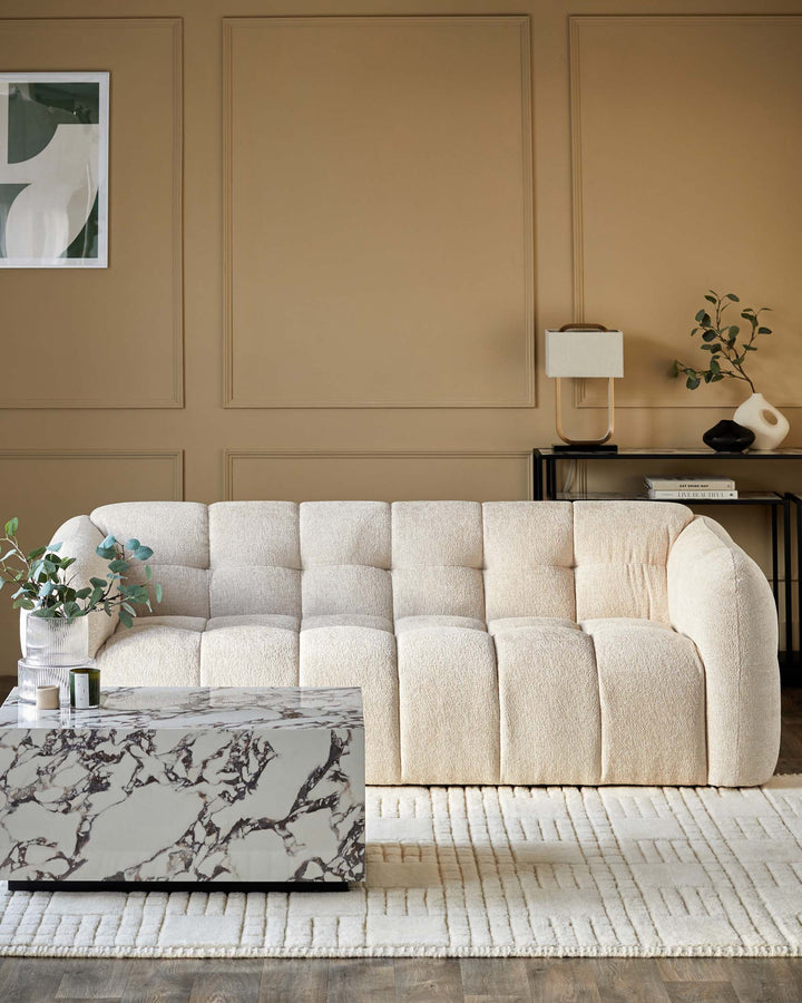A cream, fabric sofa, a marble-topped coffee table, and a black side table furnish this stylish, modern living room.