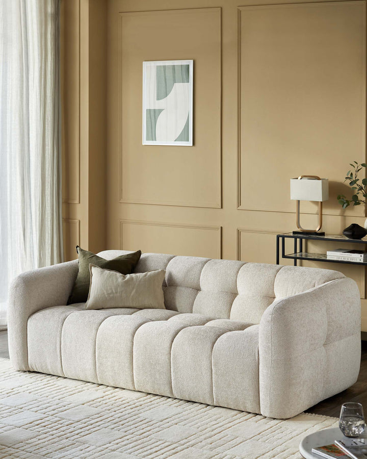 A contemporary cream sofa with olive cushions is displayed in a stylish living room with neutral decor.