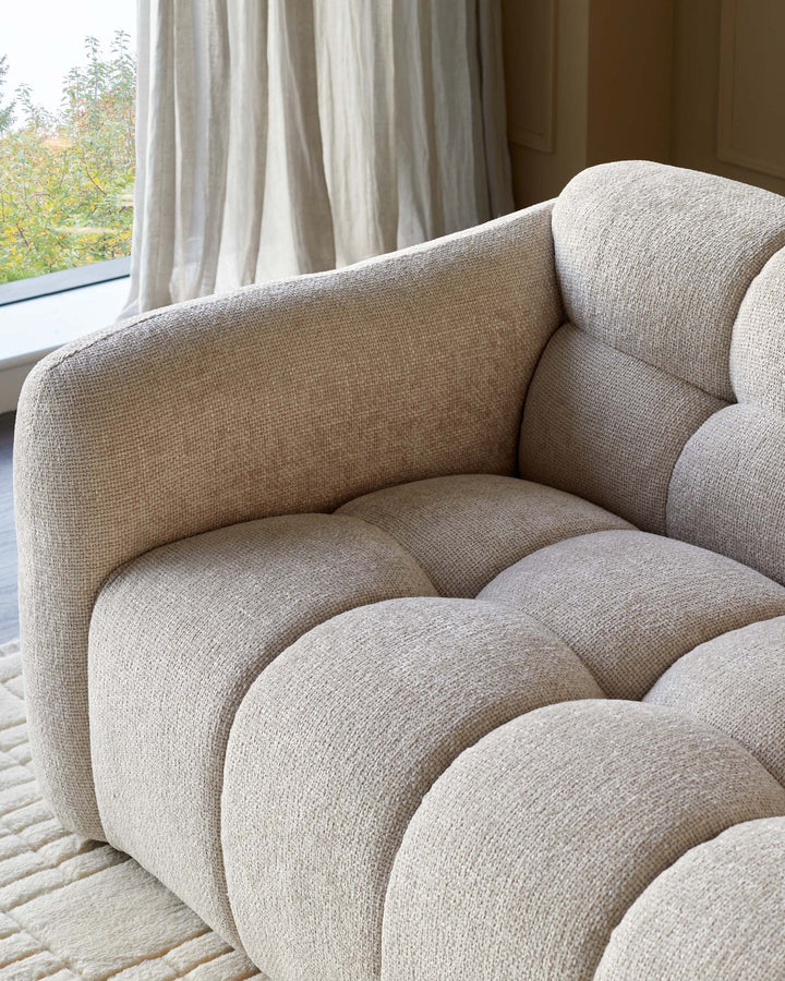 Stylish modular sofa in textured beige fabric, creating a cosy and modern living space.