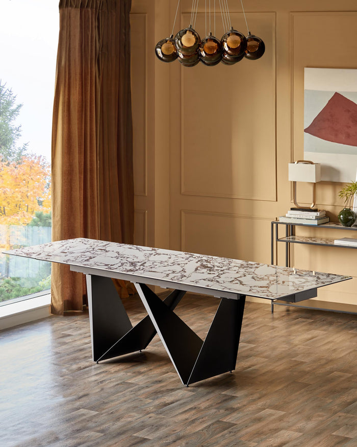 A dining room featuring a marble-effect table with black, angular legs and a modern lighting fixture.