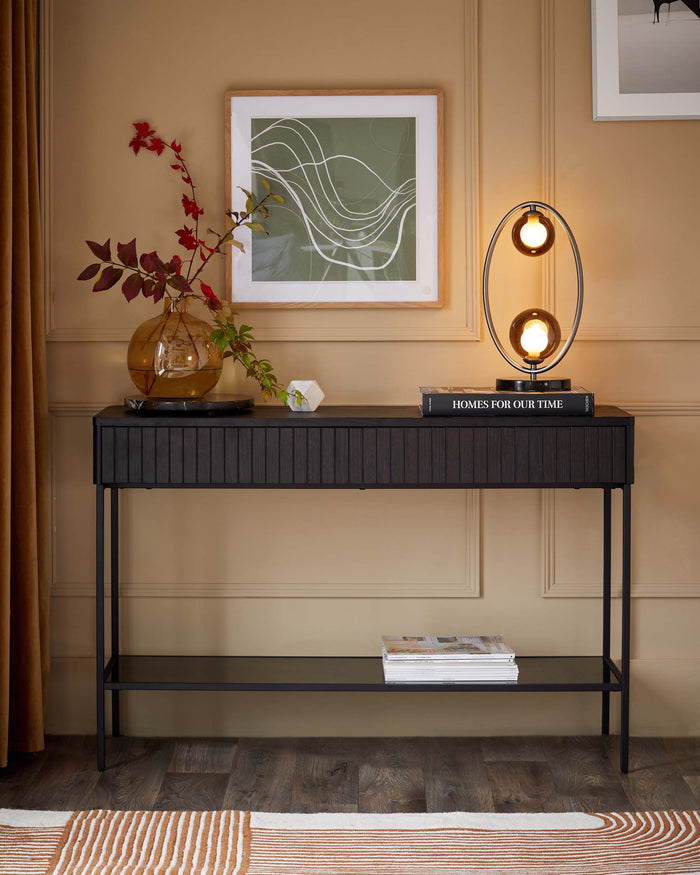 Console table in dark wood with metal frame, lamp, framed prints and accessories.