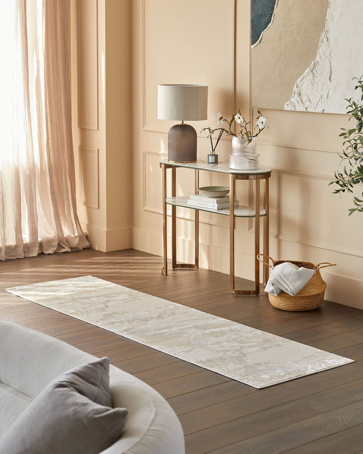 A modern interior featuring a sofa, stylish console table with lamp, and a textured rug on a wooden floor.