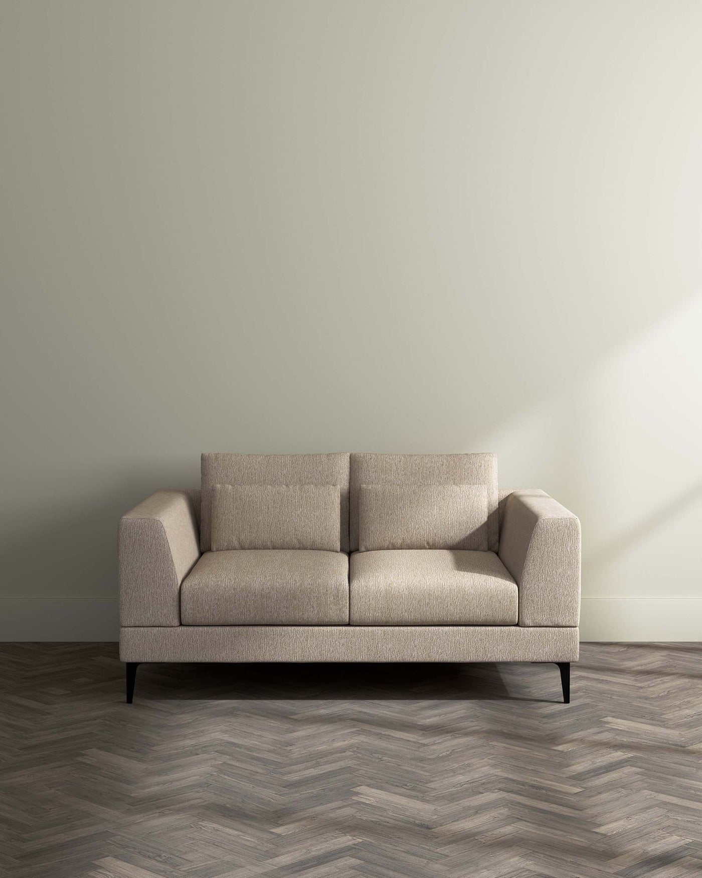 Minimalist beige fabric sofa with clean lines and dark wooden legs set against a neutral wall on a herringbone-patterned wooden floor.