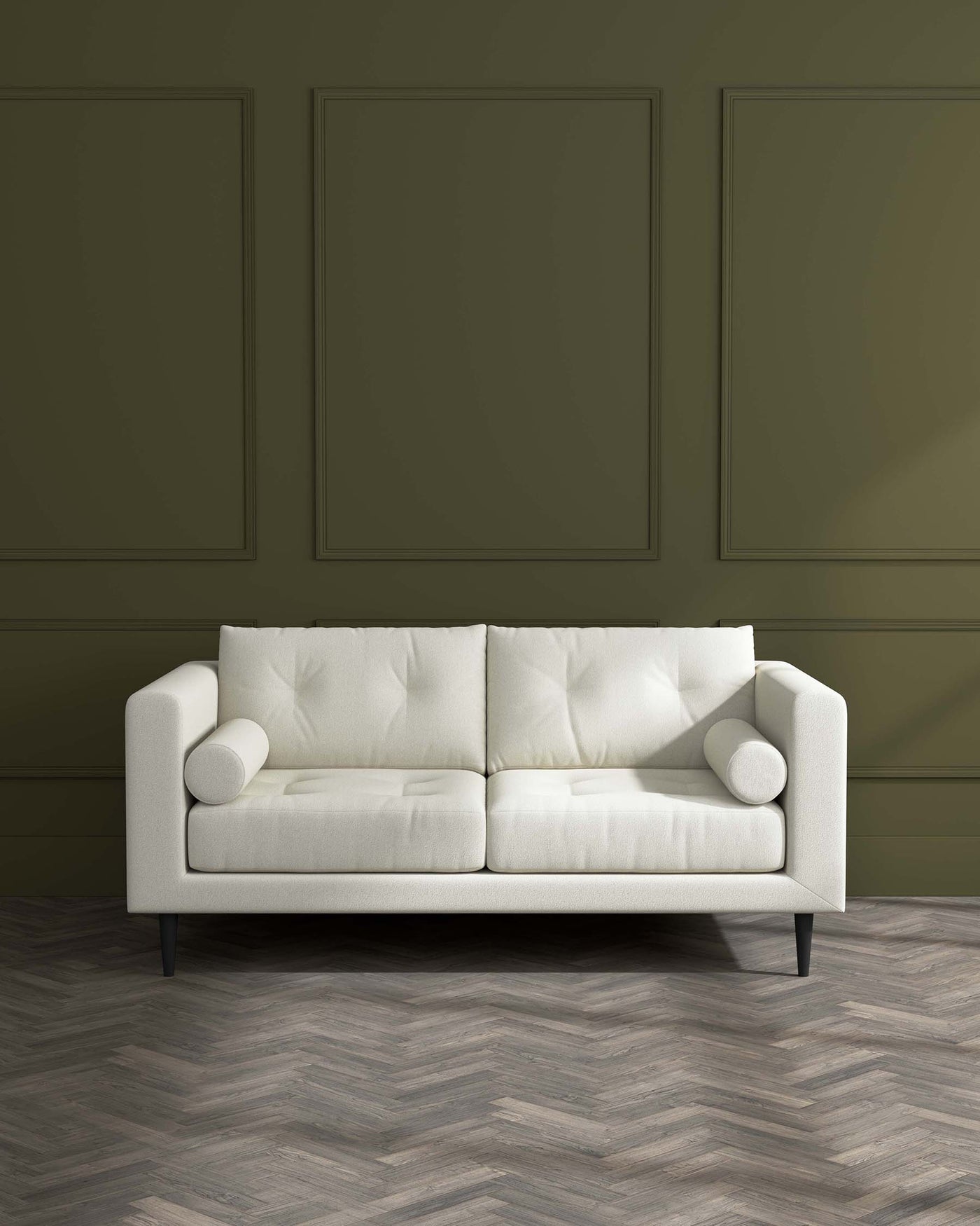 A modern light beige three-seater sofa with tufted back cushions, fitted with cylindrical side cushions and supported by dark wooden tapered legs against a dark olive green wall panel background.