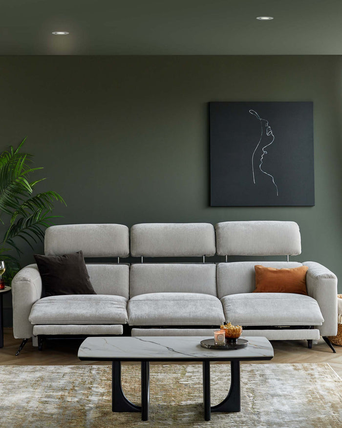Light gray sectional sofa with a decorative rust-colored pillow and a modern marble-top coffee table.