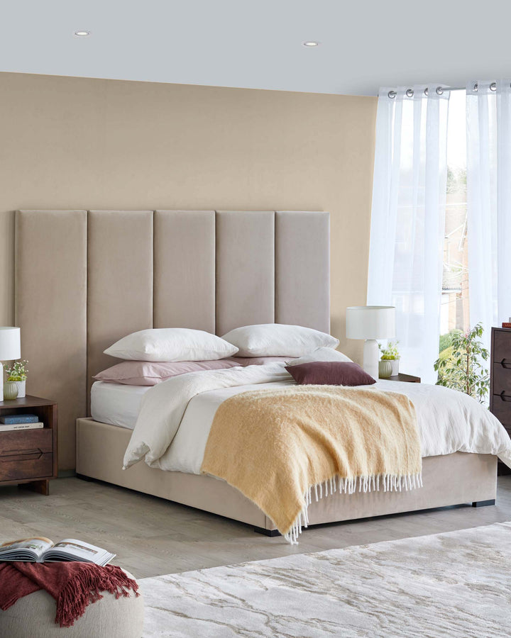 A plush bed with a tall, soft headboard, layered pillows, a cozy throw blanket, and modern bedside tables.