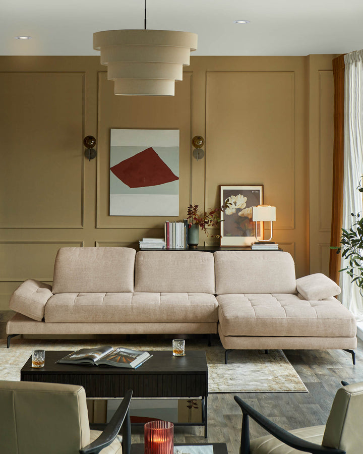 A modern living room featuring a beige sectional sofa, a dark coffee table, and warm lighting.