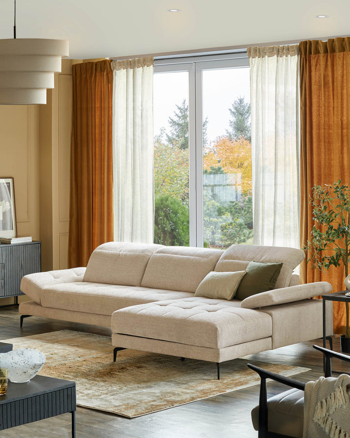 A stylish, light beige sectional sofa with green and cream cushions, set on a patterned rug in a modern living room.