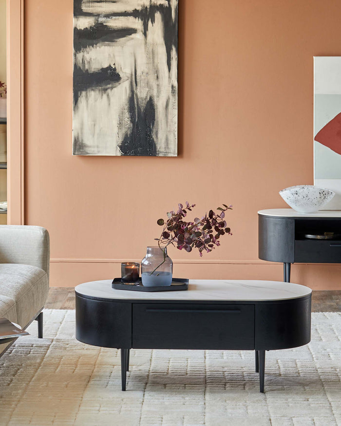 Stylish living room display with black & white coffee table and sideboard on a textured rug, complemented by modern artwork.