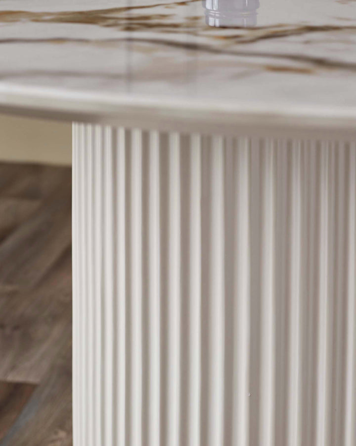 Austin 6-seater dining table with white fluted pedestal base and natural ceramic top, close-up detail view.