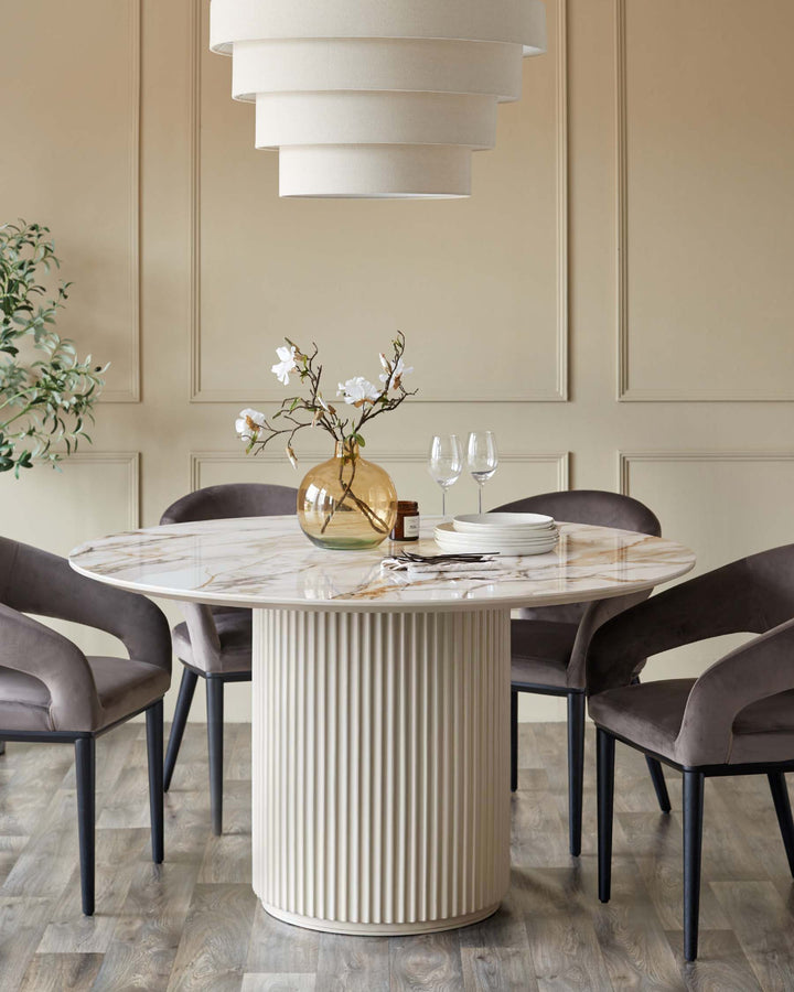 Austin natural ceramic round dining table with ribbed white pedestal base, paired with mocha Heath dining chairs.
