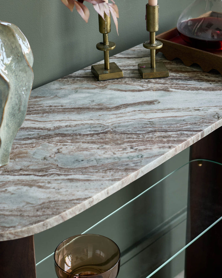 Adalynn console table with dark wood base and veined marble top, styled with brass candlesticks and decorative accessories.