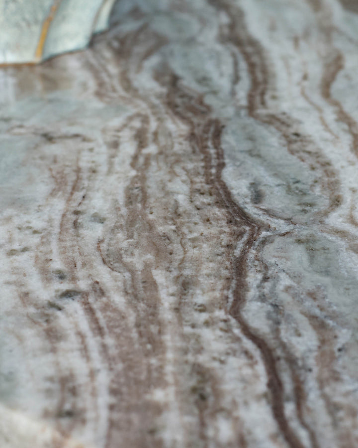 Close-up of dark Toronto marble tabletop showing natural veining and texture in cream and brown tones.