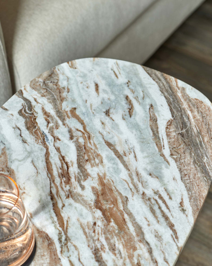 Close-up of a marble-topped side table next to a neutral-toned sofa. Perfect for modern living rooms.