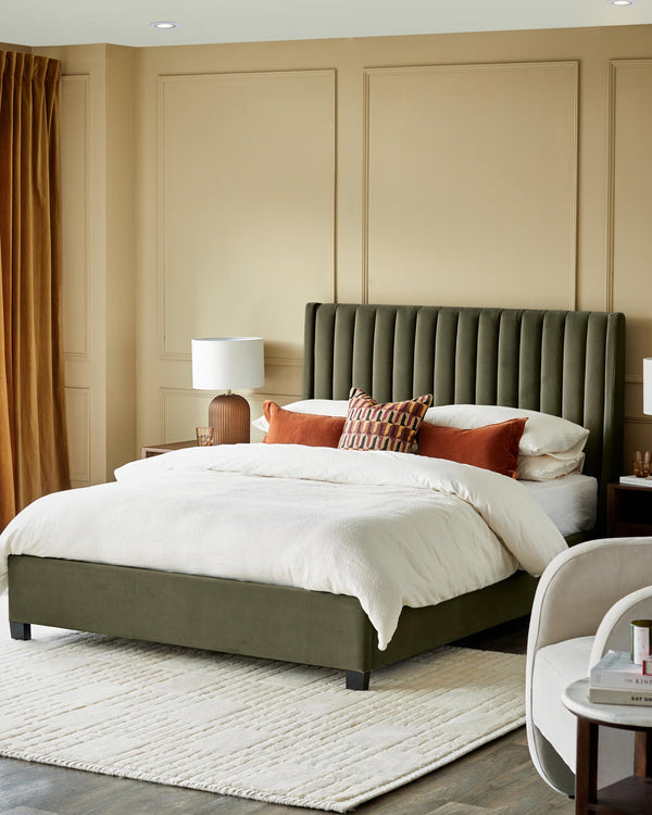 A plush olive-green bed takes centre stage, adorned with cosy cushions, inviting relaxation in style.
