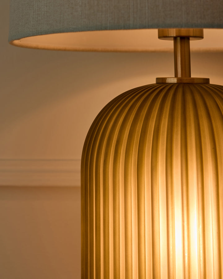 Amalfi table lamp with olive green linen shade and ribbed brass base, side detail view.