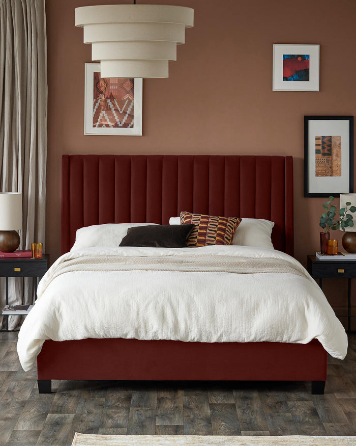 Bedroom featuring a red upholstered bed with a white duvet, flanked by black nightstands with lamps and artwork.