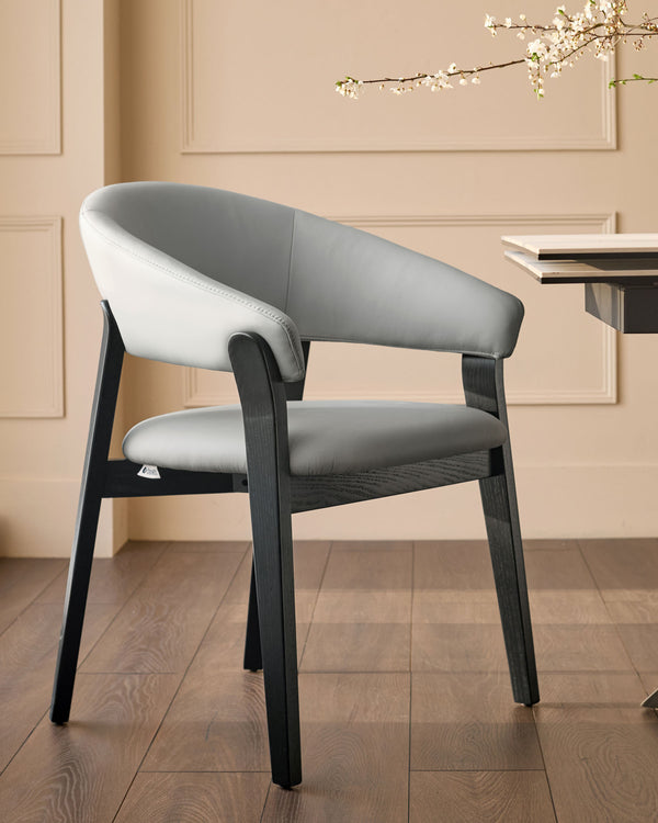 Amelia dining chair in light grey leather with dark wood frame, angled view showing curved backrest and seat.