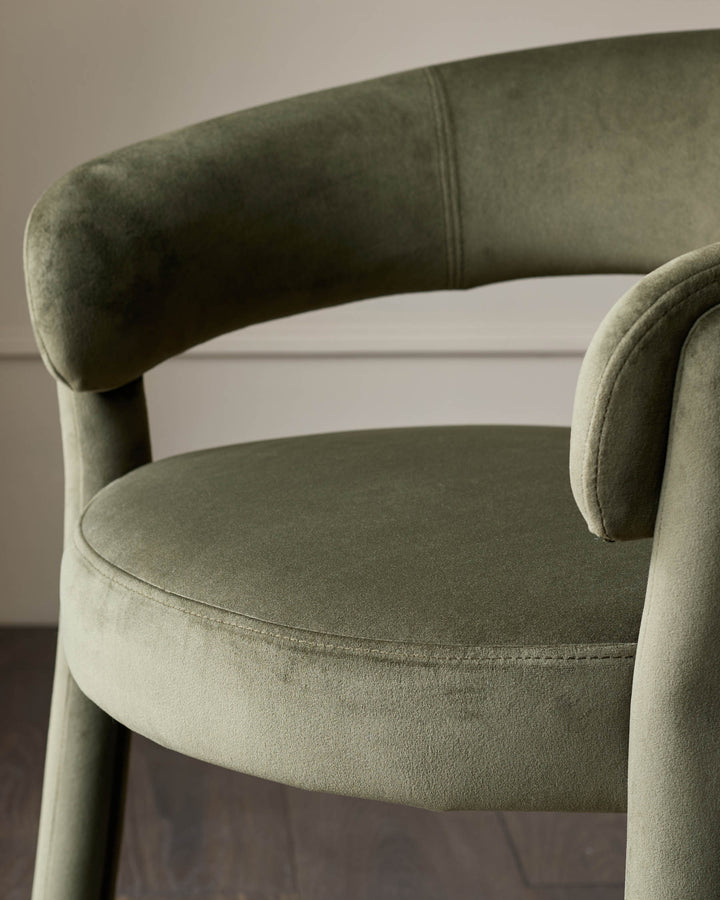 Close-up of a stylish green velvet chair, showcasing its rounded design and luxurious fabric. Perfect for adding a touch of elegance.