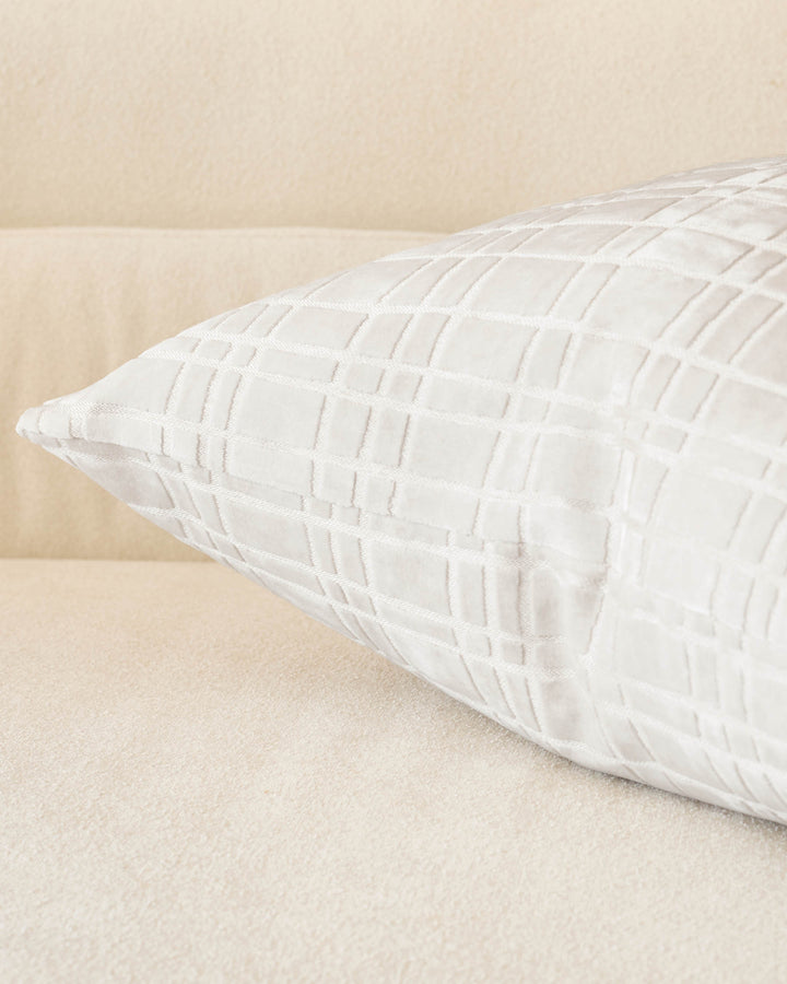 Arabella cushion in ivory with quilted geometric pattern, displayed on a neutral beige surface.