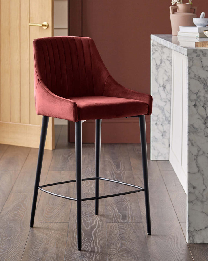 Burgundy velvet bar stool with black metal legs in a modern kitchen setting.