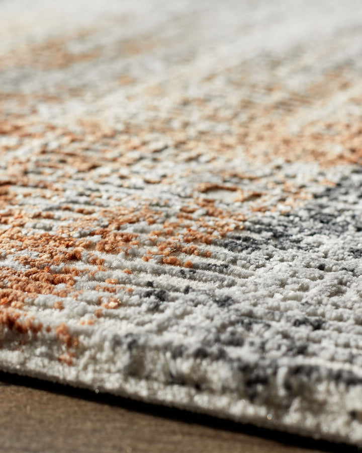 Soft-touch textured rug in terracotta and cream, close-up detail view showing plush pile and color gradient pattern.