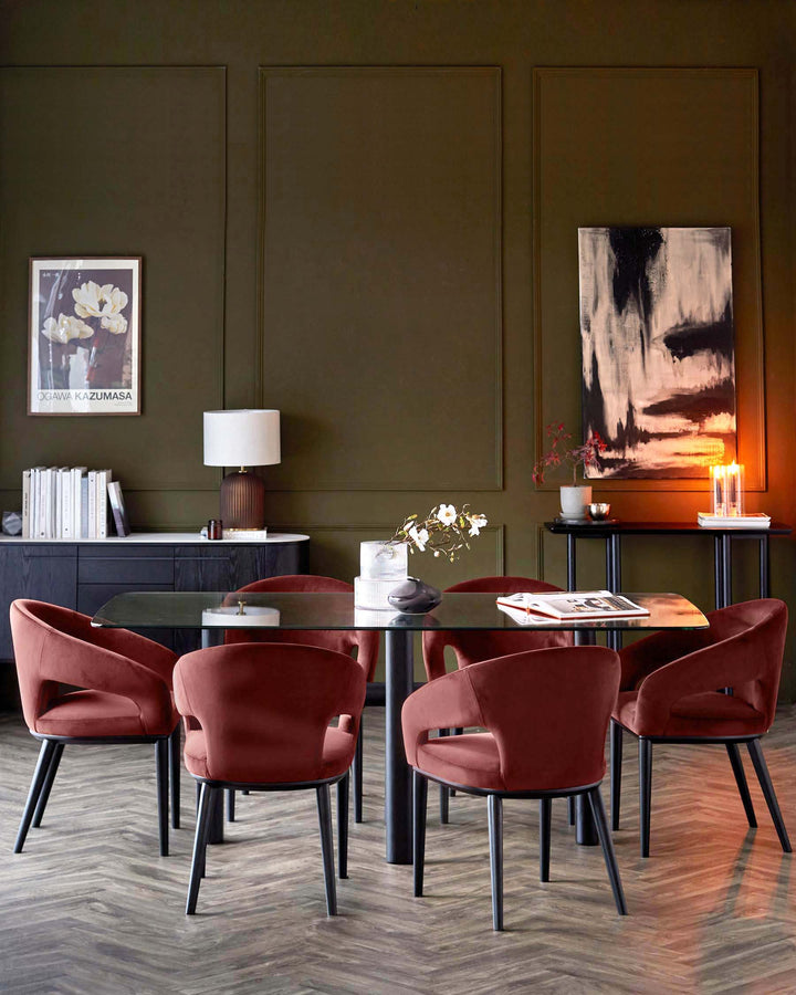 A dining room featuring a glass table with six red velvet chairs, a sideboard, and a console table.