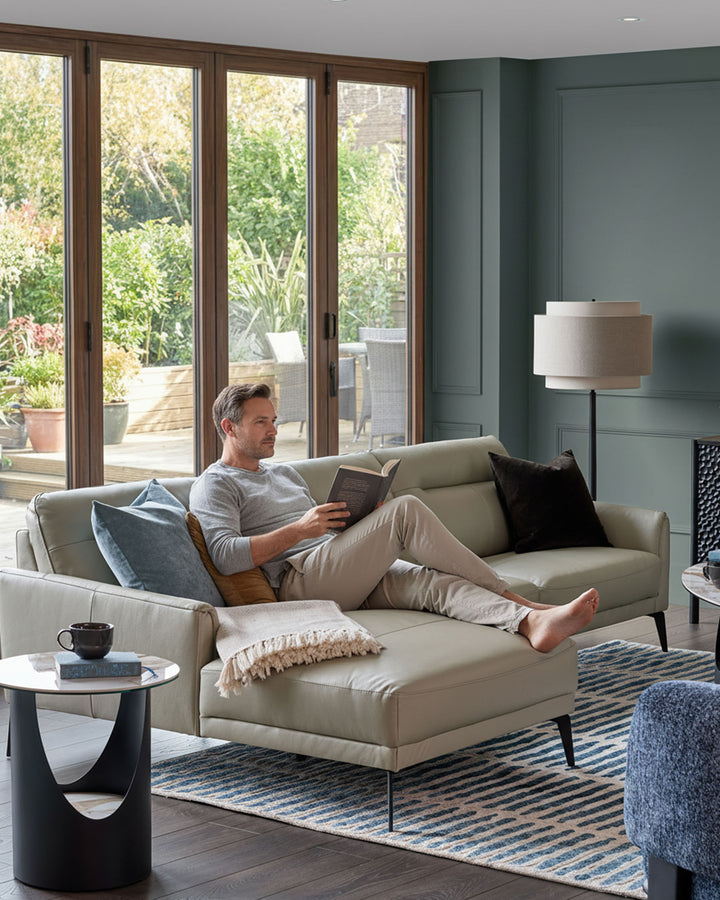 Brooks leather left-hand corner chaise sofa in light grey, styled in a modern living room with garden views.