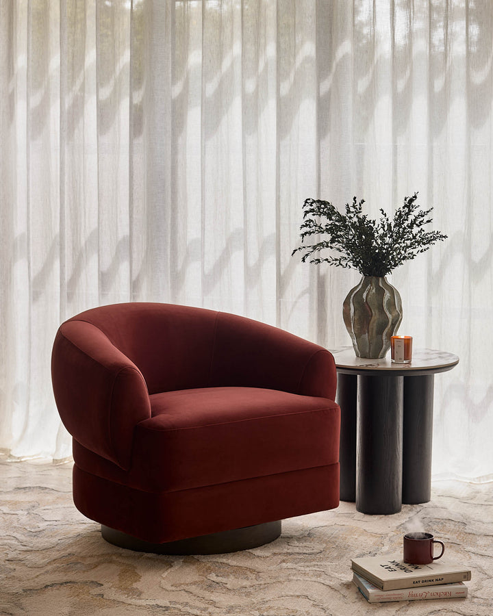 Callan accent chair in toffee red velvet with curved barrel shape, shown in styled living room setting.