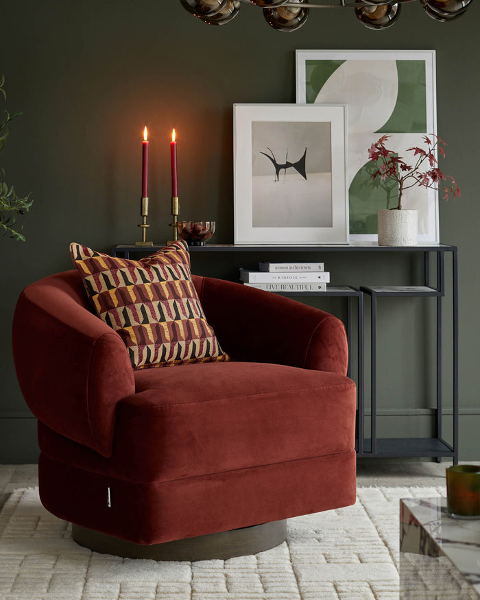 A red swivel chair with a geometric cushion sits on a patterned rug next to a console table with framed art.