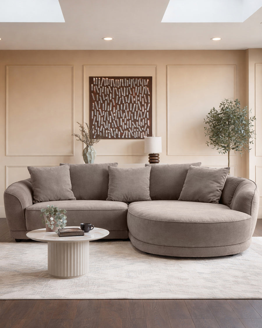 Mink fabric right-hand corner chaise sofa in a modern living room with curved seating and plush cushions.