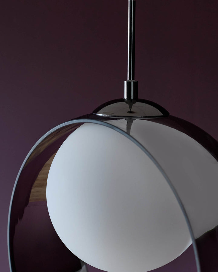 Chloe 3 pendant light with frosted white glass globe shade and polished chrome metal frame and rod against burgundy background.