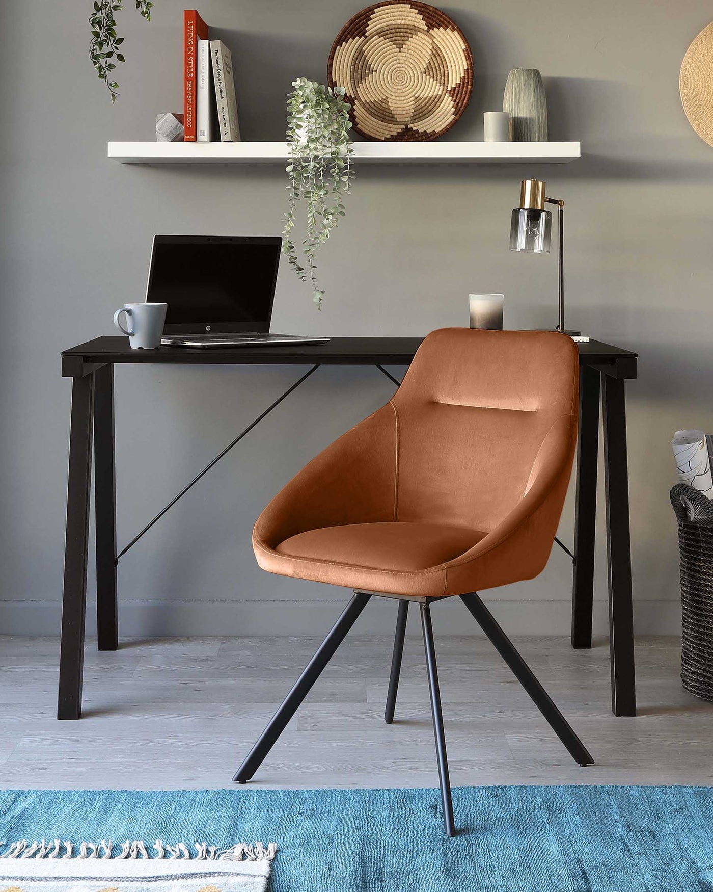 Modern minimalist black work desk paired with a stylish caramel brown upholstered chair with black metal legs, situated in an elegantly decorated room setting.