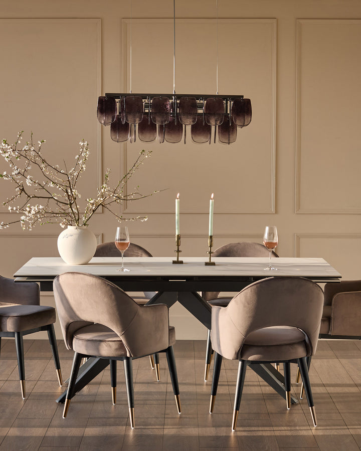 Mocha velvet dining armchair with black wooden legs and brass foot caps, shown in elegant dining room setting.