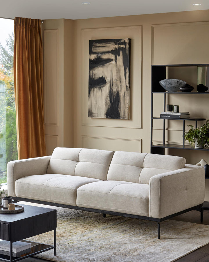 Stylish living room featuring a modern sofa, black shelving unit, coffee table, and an abstract painting.