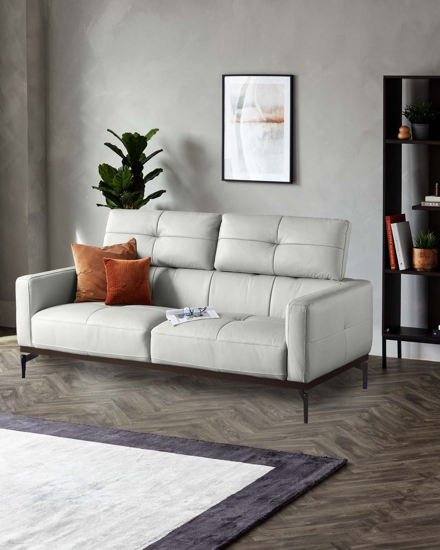 Modern light grey upholstered sectional sofa with clean lines and dark wooden legs, positioned in a stylish living room setting with a minimalist black shelving unit in the background.