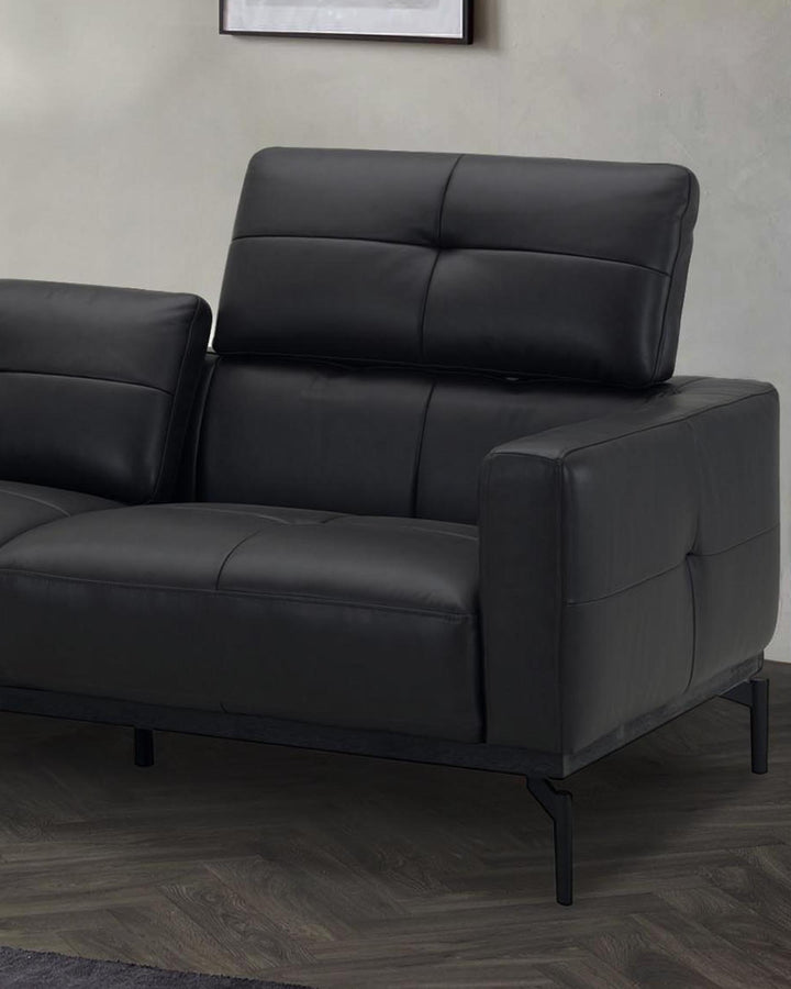 Black leather right-hand corner chaise sofa with quilted backrest and metal legs, shown from side angle in modern interior setting.