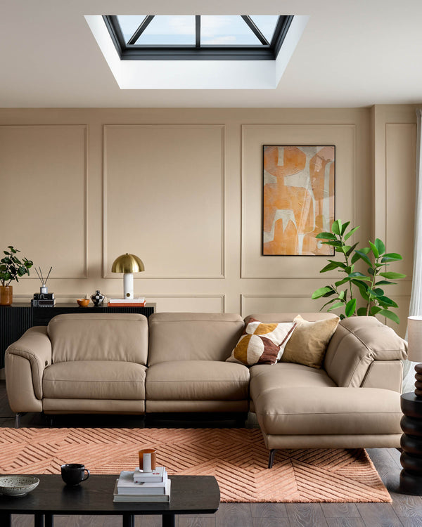 Natural leather right-hand corner chaise sofa in a contemporary living room with skylight and neutral decor.