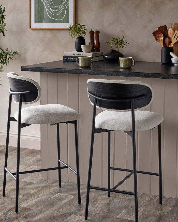 Two stylish bar stools with black frames and light grey upholstered seats, perfect for a modern kitchen or dining area.