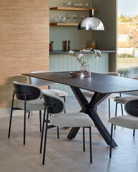 Dining room furniture: A dark grey table with black legs surrounded by light grey chairs with black frames.