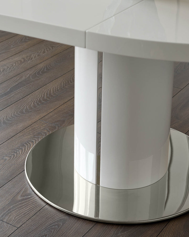 Curva gloss white round extending dining table, shown from side angle displaying curved base and extension mechanism on dark wood floor.