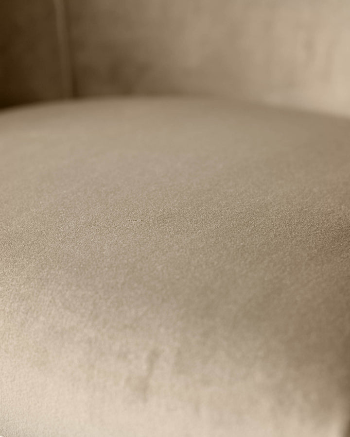 Dakota velvet barstool in champagne, close-up of upholstered seat texture and brass details.