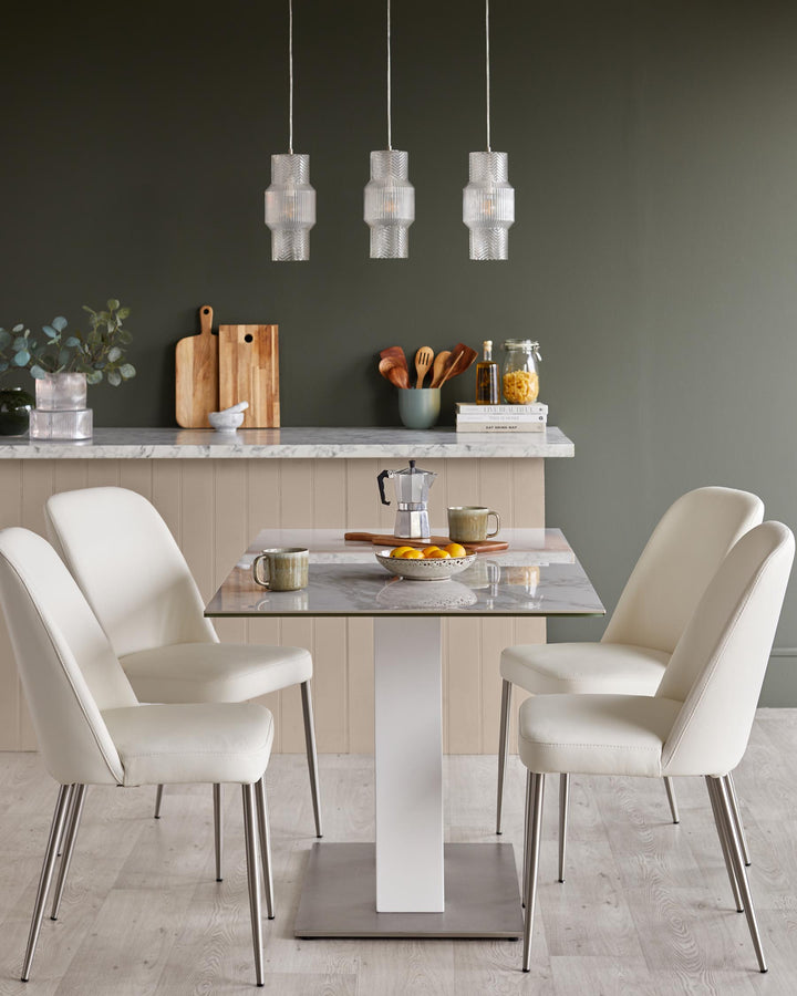 A modern dining set with marble table top, white chairs, and three hanging glass pendant lights.