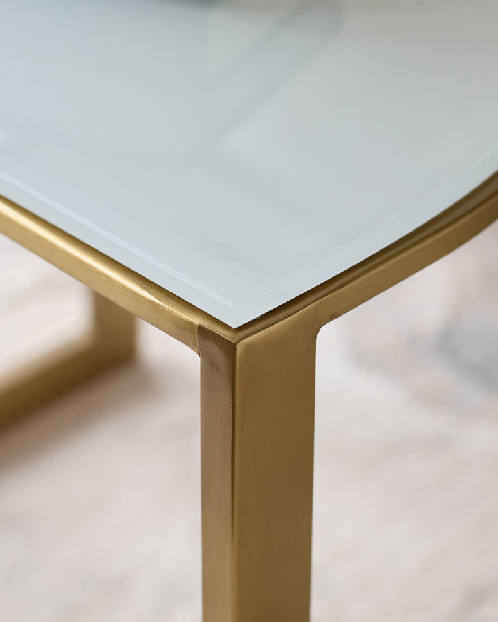 White marble top demi-side table with brushed brass legs, close-up detail view.