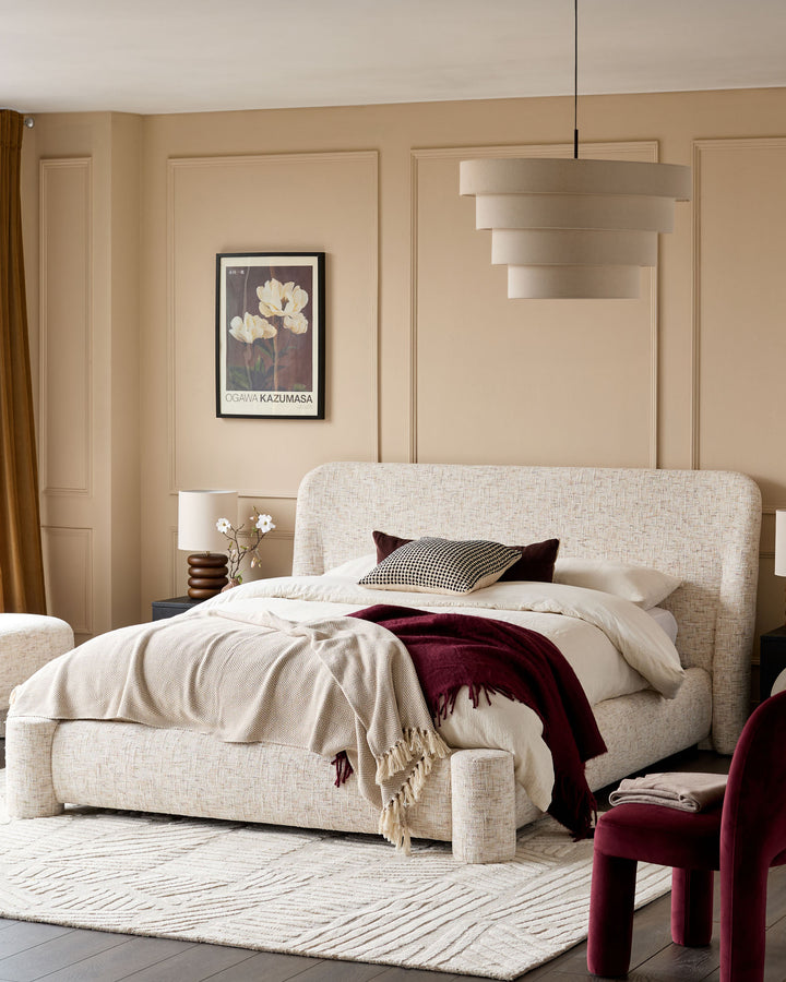 Deven king-size ottoman bed in natural beige fabric, displayed in a styled bedroom setting with neutral décor.