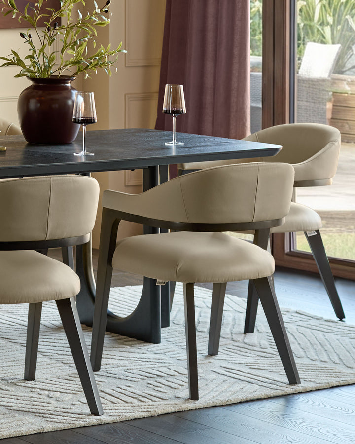 Dylan dining chair in natural leather with charcoal wooden legs, shown at oval table in modern dining room setting.