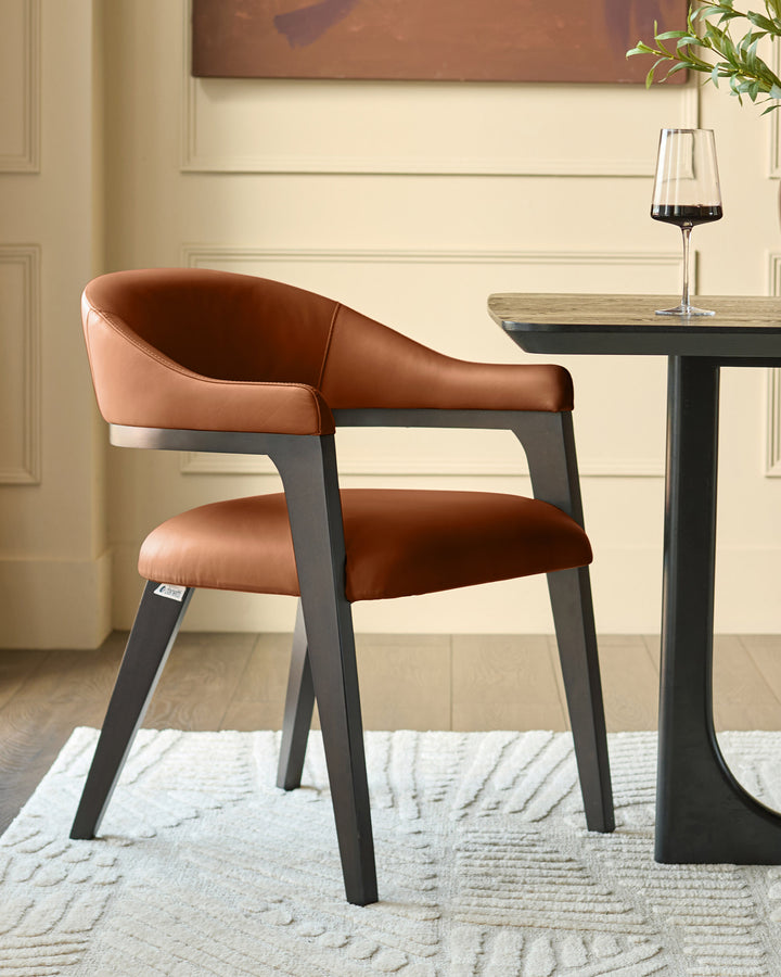 Dylan dining chair in tan leather with charcoal wood frame, shown at an angle beside a black pedestal table with wine glass.