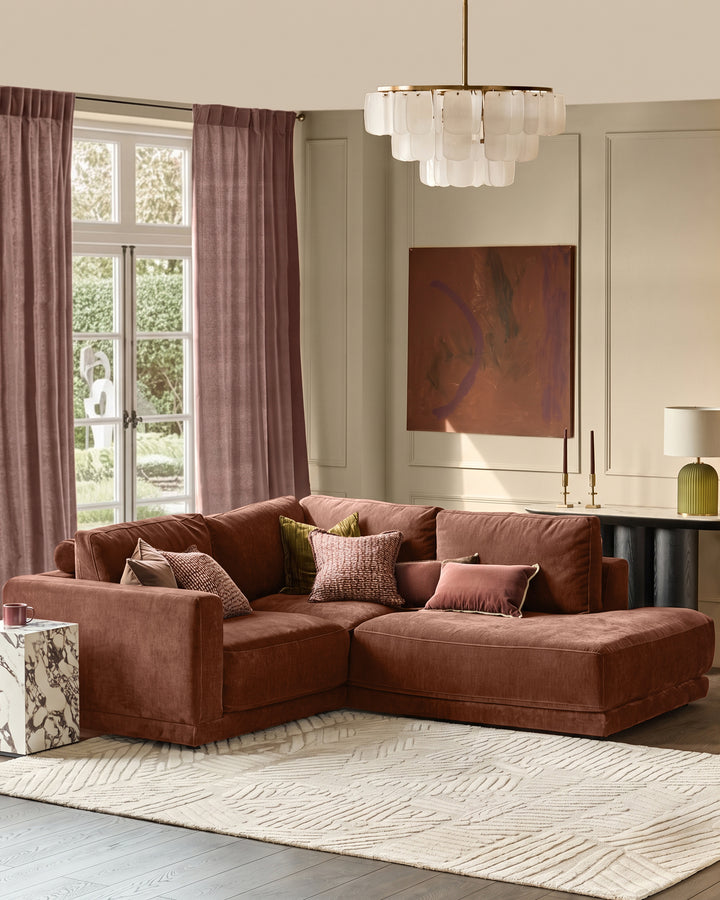 Eden Right Small Chaise Sofa in apricot fabric, displayed in a bright living room with coordinating pillows and warm lighting.