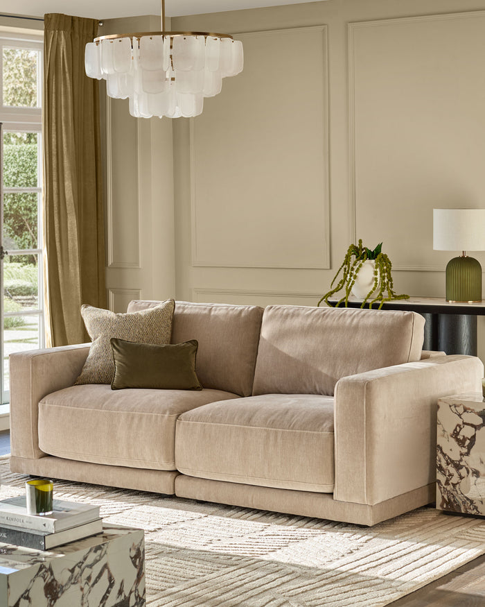 Eden 2-seater sofa in champagne fabric, displayed in a bright living room with neutral décor and modern styling.