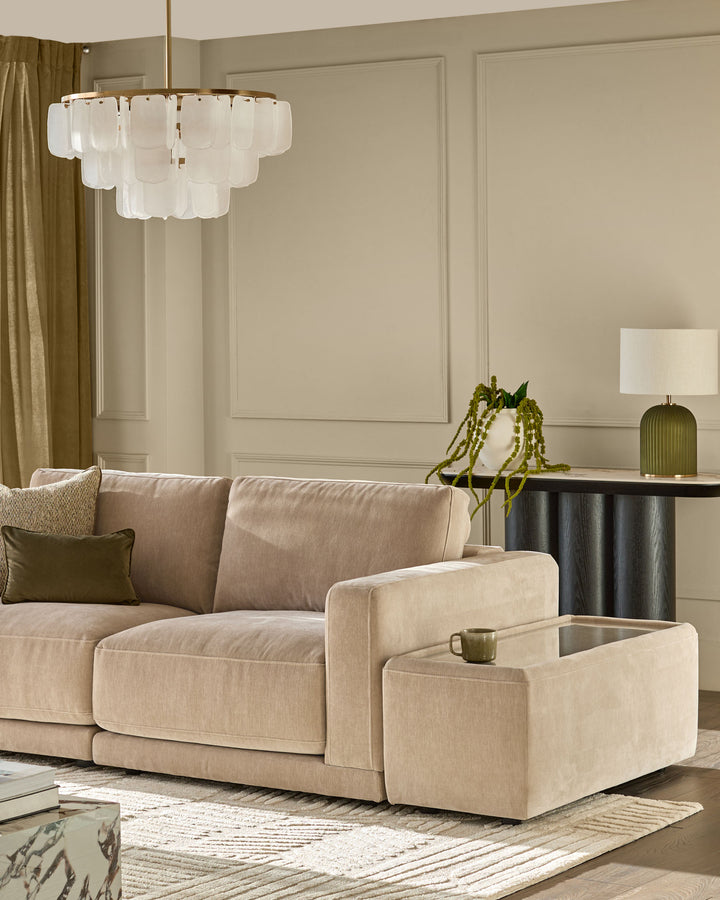 Eden side table module in champagne fabric with glass top, shown in modern living room setting.
